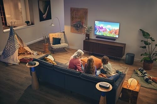 Family sitting on a couch watching TV in a cozy living room.