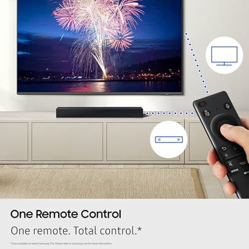 Hand holding remote pointing at TV displaying fireworks.