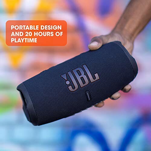 Person holding a JBL portable speaker with text about design and playtime.