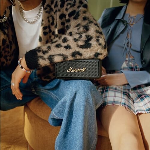 People sitting with a Marshall speaker on their lap