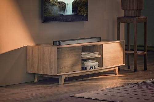 Modern wooden TV stand with storage and decor.