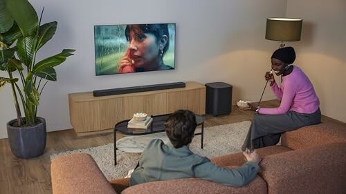 Two people watching TV in a cozy living room.