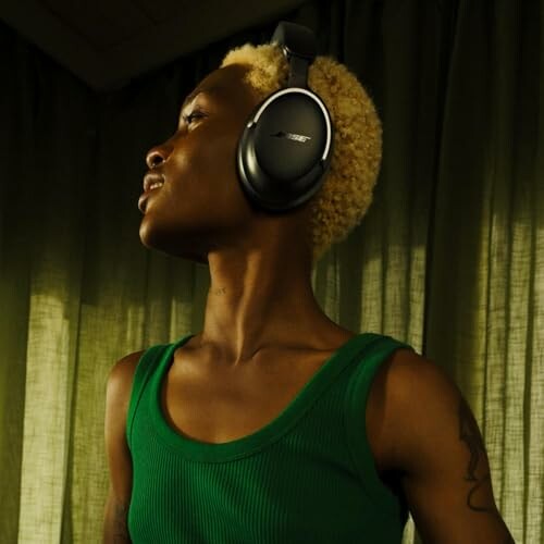 Person wearing Bose QuietComfort Ultra Headphones and green tank top